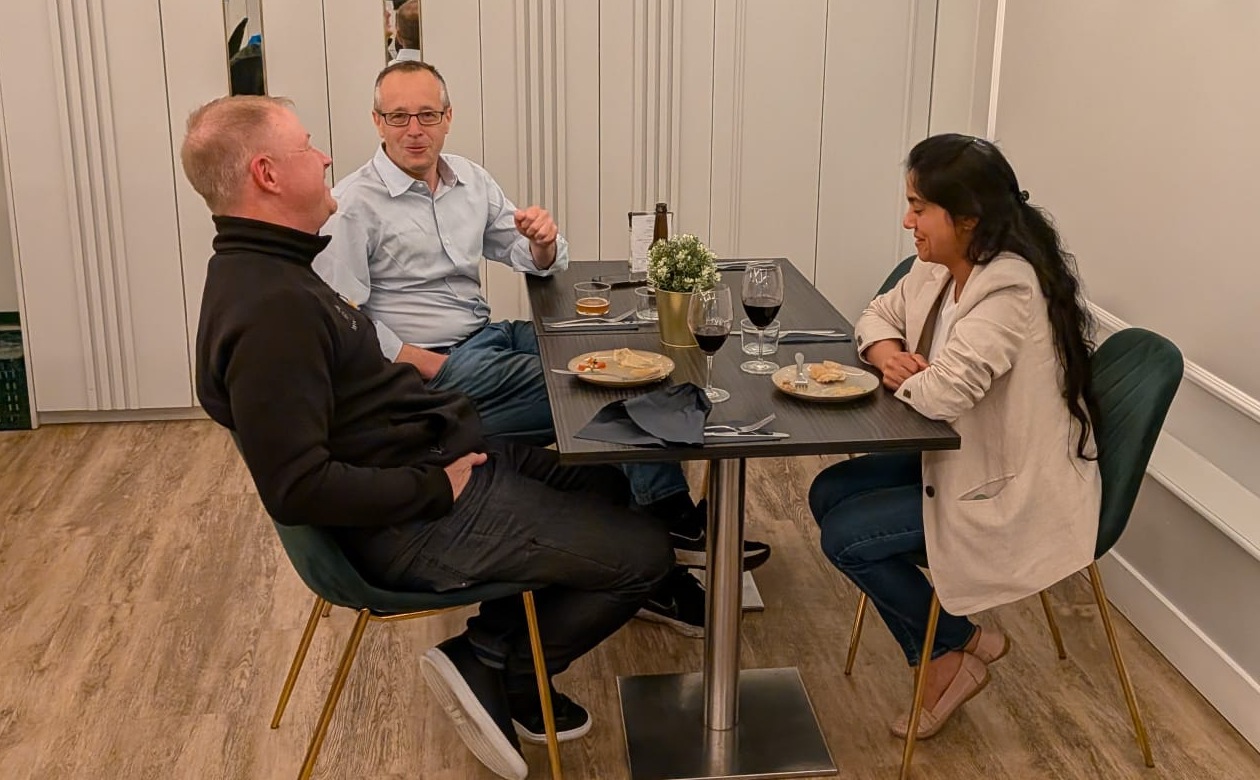 Three guests talking around a small table at an IC Dinner